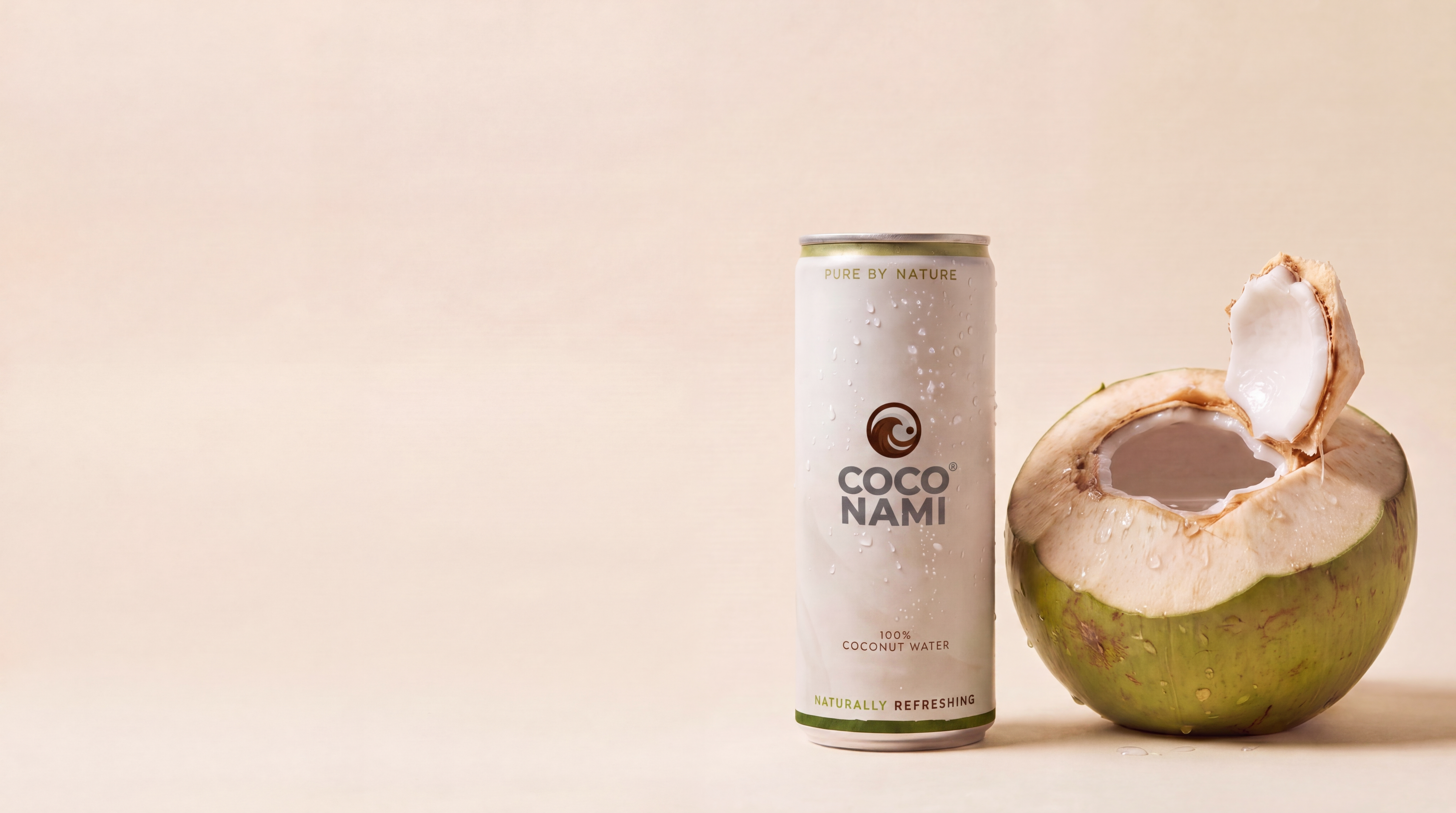 Coconami Dose neben einer frisch geöffneten Nam-Hom-Kokosnuss
